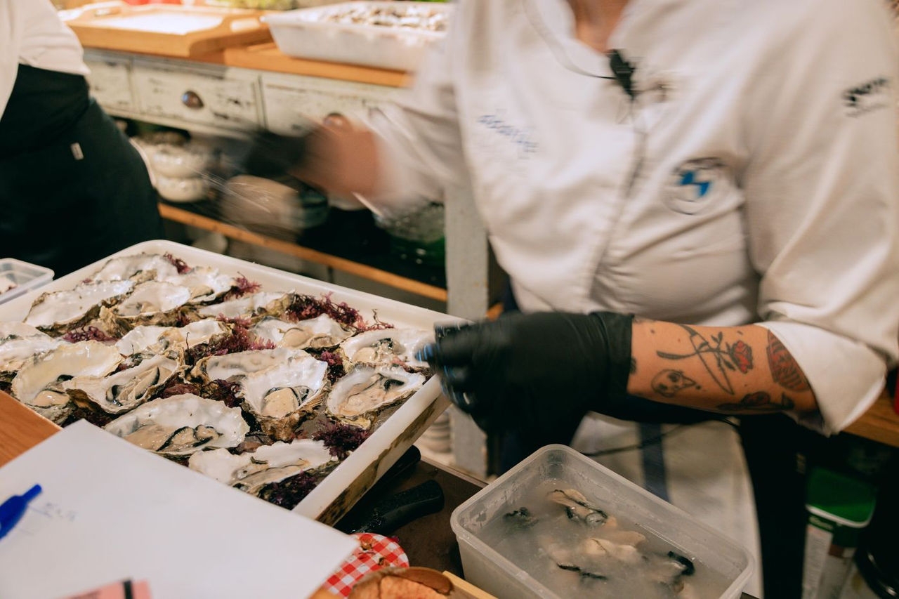 chef con una caja de ostras frescas antes de un servicio