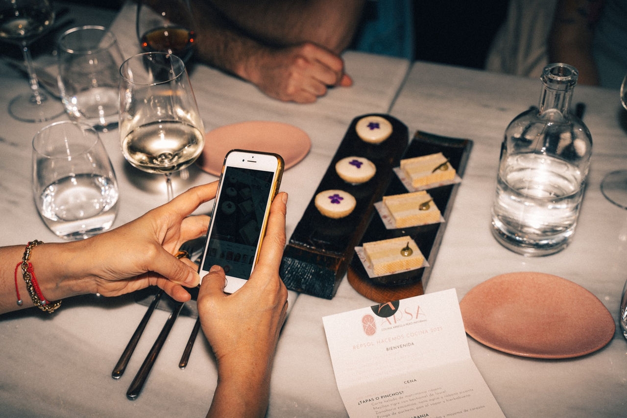 un comensal haciendo una foto a su comida